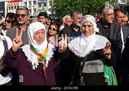 Diyarbakir, Turquie. 18 mai 2024. Deux femmes kurdes sont vues en train de faire un signe de victoire pendant la manifestation. Les lourdes peines de prison infligées aux politiciens kurdes ont été protestées par des déclarations de masse à Istanbul, Adana et Diyarbakir. Le coprésident du Parti des régions démocratiques (DBP), Cigdem Kilicgun UCAR, le président du Parti des travailleurs de Turquie (TIP), Erkan Bas, des députés du Parti de l'égalité des peuples et de la démocratie (Parti DEM), des représentants de certaines organisations de la société civile et le public ont assisté à la déclaration sur la place Dagkapi de Diyarbak?R. Crédit : SOPA images Limited/Alamy Live News Banque D'Images