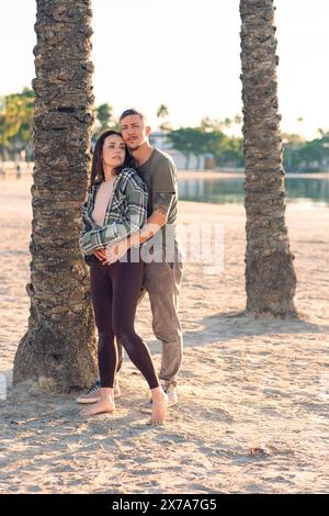 Un couple dans les câlins amoureux sur la plage de la mer. Un homme et une femme profitent mutuellement et de leurs vacances au bord de la mer. Banque D'Images