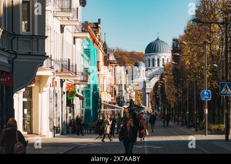 Avenue Laisvės (liberté) par un clair matin d'automne à Kaunas, Lituanie, avec sa rue bordée d'arbres et l'église de Michael l'Archange derrière Banque D'Images