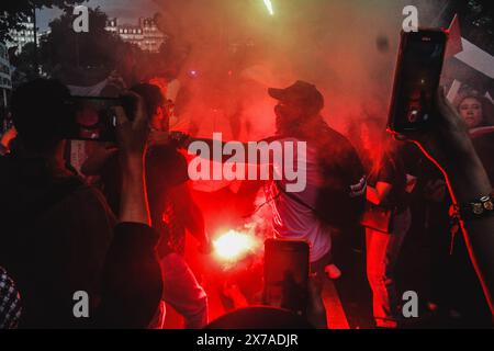 Paris, France. 18 mai 2024. Une personne allume une fusée dans une marche en soutien à la Palestine. Marche en soutien à la Palestine dans les rues principales de Paris, France ; à l'occasion du 76e anniversaire de la Nakba. Crédit : SOPA images Limited/Alamy Live News Banque D'Images