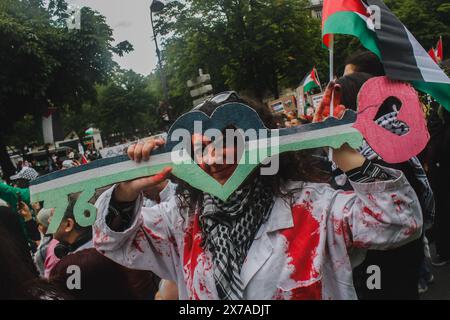 Paris, France. 18 mai 2024. Une femme soulève un signe lié aux 76 ans de la nakba. Marche en soutien à la Palestine dans les rues principales de Paris, France ; à l'occasion du 76e anniversaire de la Nakba. Crédit : SOPA images Limited/Alamy Live News Banque D'Images