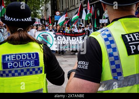 Deux policiers regardant un manifestant pro-palestinien dans une manifestation de rue anti-israélienne - Palestine Solidarity Campaign. Centre-ville de Cardiff. Banque D'Images