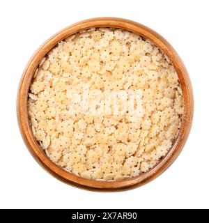 Stelle ou Stelline, variété pastina et pâtes italiennes soupes dans un bol en bois. Pâtes minutes à la semoule de blé dur non cuite. Minuscules étoiles avec trou au centre. Banque D'Images