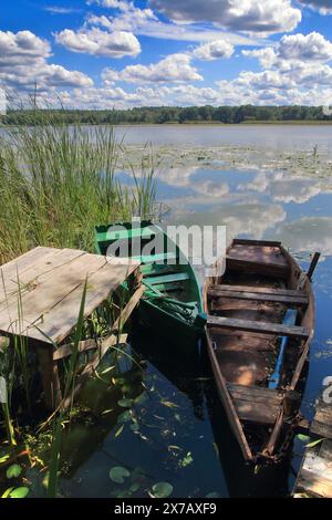 La photo a été prise en Ukraine, sur la rivière Southern Bug. La photo montre un bateau de pêche amarré près de la rive de la rivière sous un ciel bleu avec la lumière CLO Banque D'Images