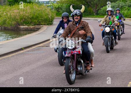 Poole, Dorset Royaume-Uni. 19 mai 2024. Bournemouth et Poole Distinguished Gentlemen’s Ride est un événement annuel, l’un des nombreux dans le monde, qui vise à recueillir des fonds et à sensibiliser le public à une cause dapper : la santé des hommes. Le plus grand DGR de Bournemouth et Poole avec 1000 coureurs (cap) s’est inscrit pour la course et a déjà récolté un montant stupéfiant de 70 000 £. Une vue à voir voir des centaines de motos, beaucoup vintage, rouler à travers Poole Park sur leur chemin à Bournemouth avec de nombreux coureurs habillés de manière appropriée, des cravates de style rétro, des moustaches et des tweeds. Crédit : Carolyn Jenkins/Alamy Live News Banque D'Images