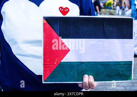 18 mai 2024, Varsovie, Mazovie, Pologne : un manifestant tient une pancarte du drapeau palestinien tout en portant un sweat-shirt Loveheart pendant la manifestation. Des manifestants pro-palestiniens organisent une manifestation contre la mort sur la place du château de Varsovie. En commémoration de la Nakba à partir de 1948, les manifestants étaient immobiles sur le sol. Par la suite, un certain nombre de Palestiniens et de Polonais-Palestiniens ont raconté leurs histoires au public réuni. (Crédit image : © Neil Milton/SOPA images via ZUMA Press Wire) USAGE ÉDITORIAL SEULEMENT! Non destiné à UN USAGE commercial ! Banque D'Images