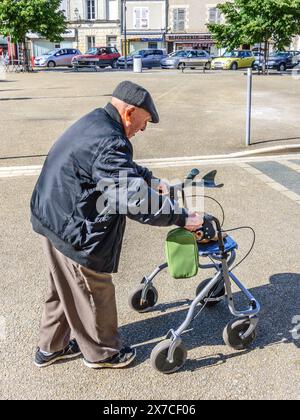 Homme âgé marchant avec cadre de marche mobile pour le soutien - le Blanc, Indre (36), France. Banque D'Images