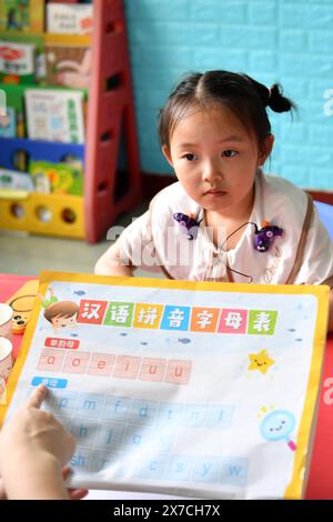 (240519) -- CHANGSHA, 19 mai 2024 (Xinhua) -- sa fille Zhang Yuhan suit un cours dans un centre de réadaptation auditive à Changsha, dans la province du Hunan, au centre de la Chine, le 16 mai 2024. Bien que malentendants, Zhang Yongsheng et sa femme Zhan Jingwen ont réussi à faire entendre leur fille, qui souffre également du même handicap, à l'âge de deux ans. En tenant un stand de collation sur un marché nocturne et grâce au soutien de leurs proches et amis, le couple a réussi à se procurer un implant cochléaire pour l'oreille gauche de sa fille et une prothèse auditive pour l'oreille droite de celle-ci. « C'est trop cher d'avoir t Banque D'Images