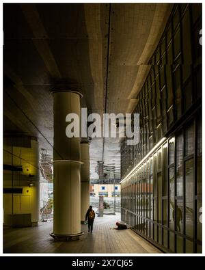 Passage de bâtiment avec colonne et plafond réfléchissant fournissant une image miroir du bâtiment et du passage et les deux personnes dans la scène Banque D'Images