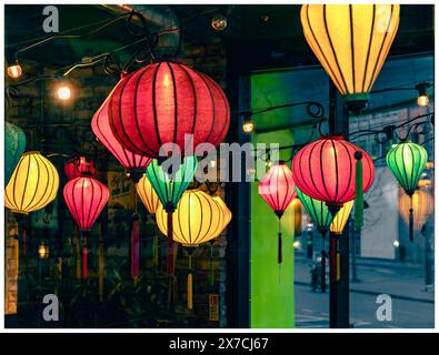 Lanternes colorées de style chinois suspendues dans un restaurant et vues à travers la fenêtre vitrée et de l'autre côté Banque D'Images