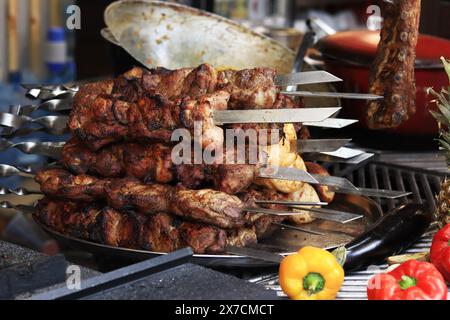 Kebabs sur brochettes, gros plan. Aire de restauration à la foire, cuisine extérieure. Nourriture chaude et savoureuse. Kebab cuit et légumes Banque D'Images