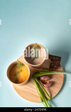 Soupe de légumes et soupe de crème de champignons dans des tasses jetables en papier pour emporter ou livraison de nourriture, plat, vue de dessus Banque D'Images