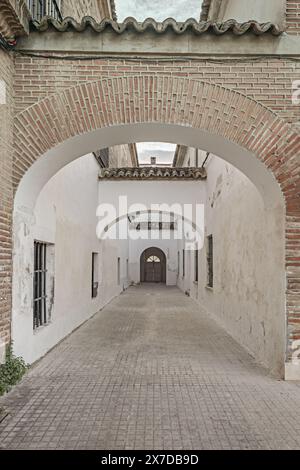 Un couloir avec des murs blanchis à la chaux dans un bâtiment monumental avec des façades en briques et de grandes arcades avec des toits en terre cuite Banque D'Images