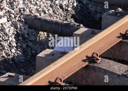 Étiquette de dérivation d'enquête sur un accident ferroviaire sur la conduite d'eau endommagée par une machine de bourrage sur le site du déraillement de train à Grange Over Sands Banque D'Images