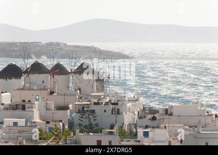 Vue panoramique d'en haut des célèbres moulins de l'île de Mykonos et de la vieille ville, en arrière-plan la mer balayée par le vent en Grèce Banque D'Images