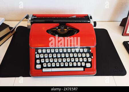 Vue de dessus du lieu de travail de bureau blanc avec machine à écrire vintage rouge vif Banque D'Images