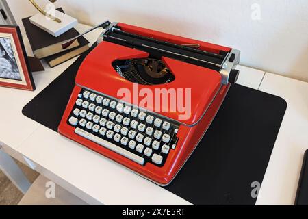 Vue aérienne inclinée du bureau blanc avec machine à écrire vintage rouge vif Banque D'Images