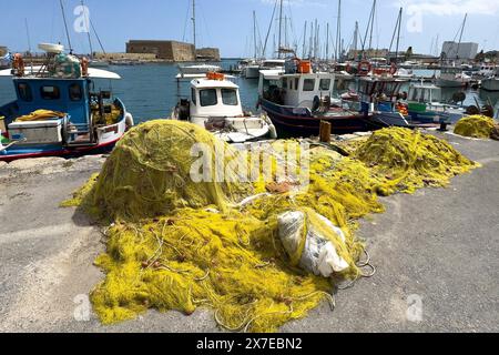 Au premier plan des filets de pêche jaunes de pêcheurs grecs locaux derrière eux plusieurs petits bateaux de pêche, en arrière-plan forteresse historique construite Banque D'Images