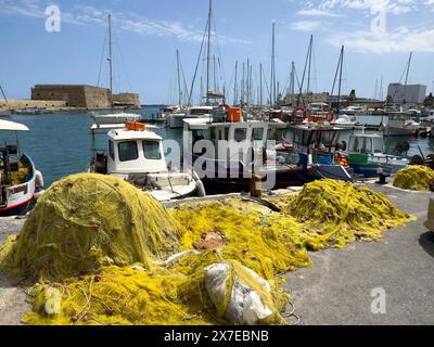 Au premier plan des filets de pêche jaunes de pêcheurs grecs locaux derrière eux plusieurs petits bateaux de pêche, en arrière-plan forteresse historique construite Banque D'Images