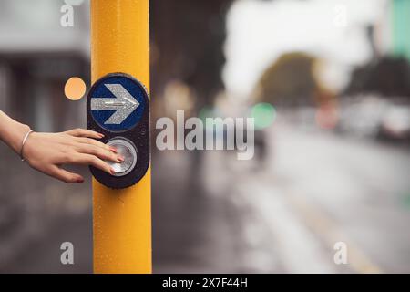 Voyage, main et femme avec bouton par feu de circulation pour traverser l'intersection avec la sécurité. Passage, panneau fléché et piéton féminin à l'arrêt pour Banque D'Images