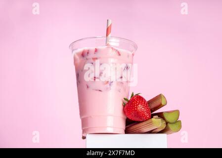 Milkshake à la fraise et à la rhubarbe, cocktail crémeux glacé avec crème glacée fouettée, rhubarbe et fraises tranchées Banque D'Images