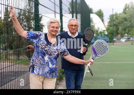 Portrait d'une femme senior sportive en forme de padel jouant au padel sur terrain ouvert le jour d'été, prête à frapper la balle. Concept de santé et de mode de vie actif.. Banque D'Images