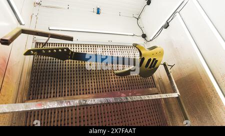 guitare en bronze nouvellement colorée suspendue dans l'atelier pour se sécher, usine de guitare. Photo de haute qualité Banque D'Images
