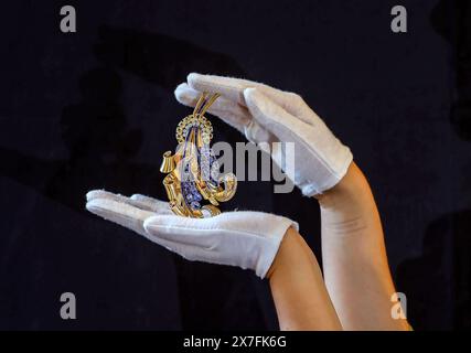 Olympia Auctions London 20 mai 2024.broche rétro en or, saphir et diamant, 1940, conçue comme un panache stylisé de plumes spiralées d'or, ornée de tiges de saphir taillées calibrées et de diamants simple taillés, et des sprays foliés de saphirs ovales coupés mixtes, attachés avec un motif en croissant de saphirs ovales coupés mixtes jaunes et de diamants coupés circulaires, 12cm x 6cm, 69g est £3 000-5 000. Date des enchères 23-mai 2024,25 Blythe Road. Crédit : Paul Quezada-Neiman/Alamy Live News Banque D'Images