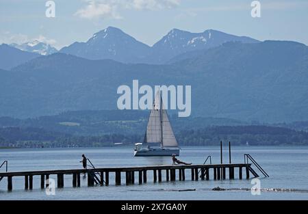 Seebruck, Allemagne. 20 mai 2024. Un voilier passe devant une jetée par temps ensoleillé sur le lac Chiemsee en haute-Bavière. Crédit : Uwe Lein/dpa/Alamy Live News Banque D'Images