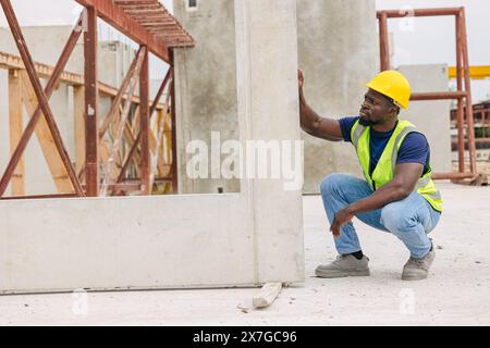 Ingénieur contrôle de qualité dans la fabrication de moulage de béton préfabriqué vérifiant les produits de qualité standard site de construction extérieur, travailleur noir africain Banque D'Images