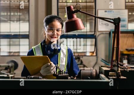 Portrait heureux ouvrier d'ingénieur avec des lunettes de protection des yeux de sécurité professionnel travaillant avec l'usine d'industrie lourde de fraiseuse de tour en métal. Banque D'Images