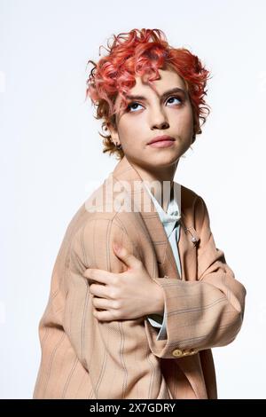 Femme élégante avec des cheveux rouges vibrants frappant une pose pour un appareil photo. Banque D'Images