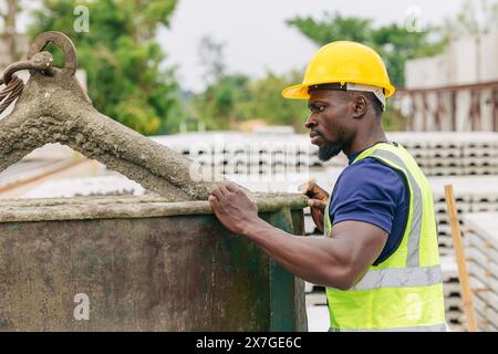 Ingénieur contrôle de qualité dans la fabrication de moulage de béton préfabriqué vérifiant les produits de qualité standard site de construction extérieur, travailleur noir africain Banque D'Images