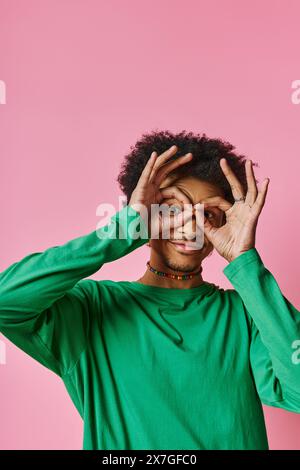 l'homme afro-américain aux cheveux bouclés couvre ses yeux avec des mains. Banque D'Images