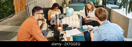 Un groupe diversifié de collègues s'engagent dans une discussion animée tout en étant assis autour d'une table, chacun concentré sur son téléphone cellulaire. Banque D'Images