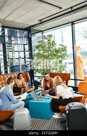 Des collègues multiculturels en tenue décontractée se sont réunis autour d'une table dans une salle de discussion lors d'un voyage d'affaires. Banque D'Images