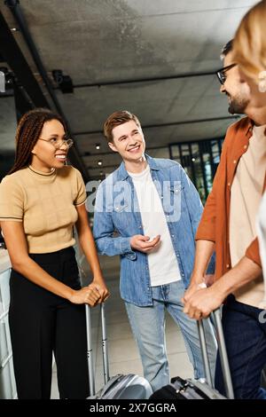 Collègues multiculturels dans une tenue décontractée dans le hall de l'hôtel avec des bagages, prêts pour un voyage d'affaires. Banque D'Images