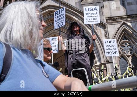 Londres, Royaume-Uni, 20 mai 2024. Un partisan de Julian Assange tient deux pancartes devant les cours royales de justice. Crédit : James Willoughby/Alamy Live News Banque D'Images