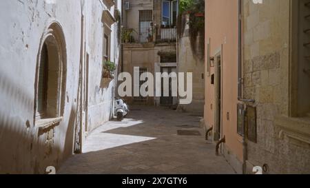 Ruelle tranquille à lecce, pouilles avec de vieux bâtiments et un scooter garé représentant le charme pittoresque et historique de cette ville italienne sur un d ensoleillé Banque D'Images