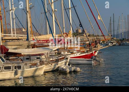 Bodrum, Turquie - 8 septembre 2023 : gros plan de yachts avec mâts dans la marina sur fond de château de Pierre au coucher du soleil Banque D'Images