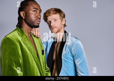 Deux hommes multiculturels dans un style élégant dapper debout ensemble sur fond gris. Banque D'Images