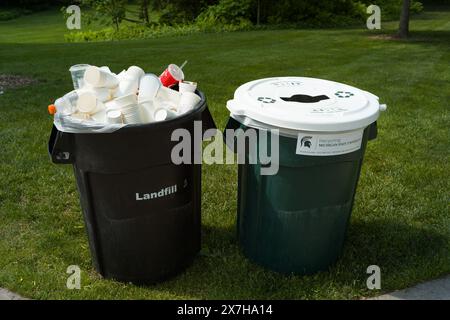 Une poubelle de recyclage et une poubelle d'enfouissement débordant sur le campus de l'Université d'État du Michigan, East Lansing Michigan USA Banque D'Images