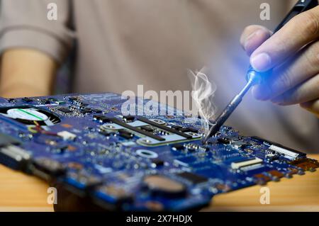 Concept de technicien réparant la carte mère de l'ordinateur, les circuits de soudure Banque D'Images
