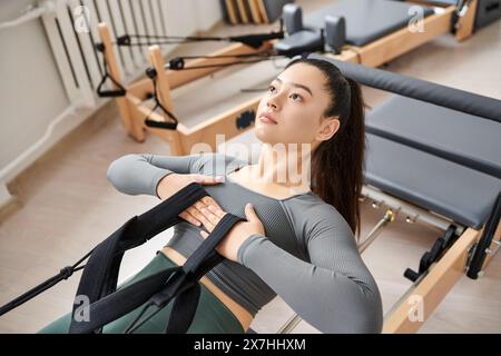 Femme séduisante pratiquant activement pendant la leçon de pilates. Banque D'Images
