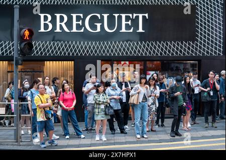 Hong Kong, Chine. 20 mai 2024. Des piétons attendent à un feu de circulation devant le fabricant suisse de montres, horloges et bijoux de luxe Breguet, à Hong Kong. Crédit : SOPA images Limited/Alamy Live News Banque D'Images