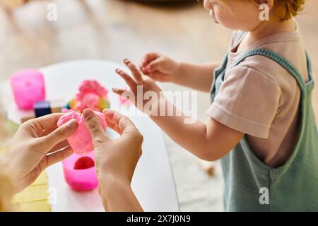 Mère guide ses filles en bas âge remettre une table, s'engageant dans une activité éducative Montessori à la maison. Banque D'Images