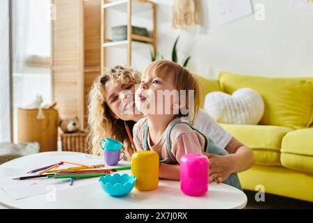 Une mère aux cheveux bouclés et sa fille en bas âge jouant joyeusement avec des jouets dans leur salon confortable. Banque D'Images