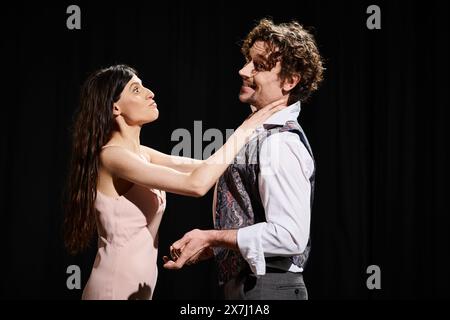 Homme et femme se tiennent ensemble sous les projecteurs sur scène. Banque D'Images