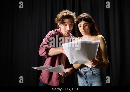 Bel homme se tient à côté d'une femme tenant des papiers, répétant pour la performance théâtrale. Banque D'Images