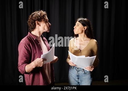 Bel homme se tient à côté d'une femme tenant des papiers, répétant pour la performance théâtrale. Banque D'Images